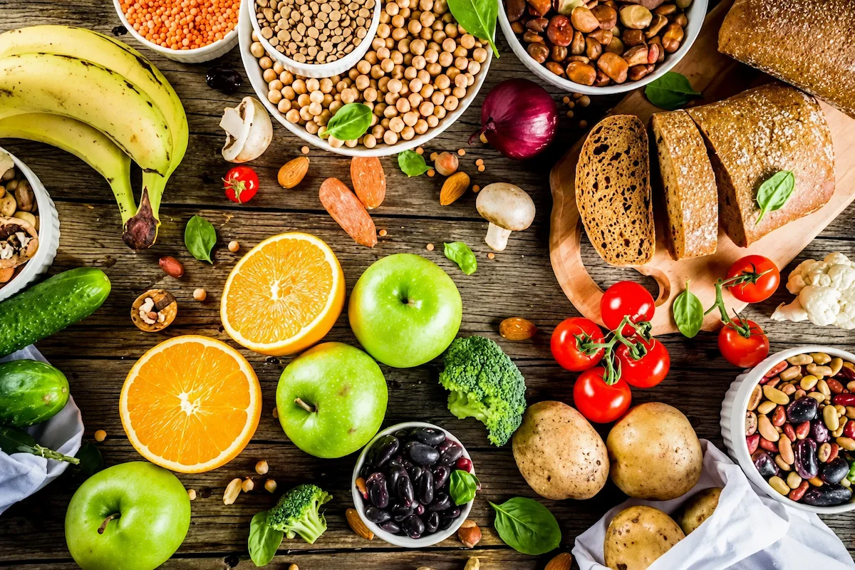 Mesa com frutas, legumes, grãos, pães e castanhas